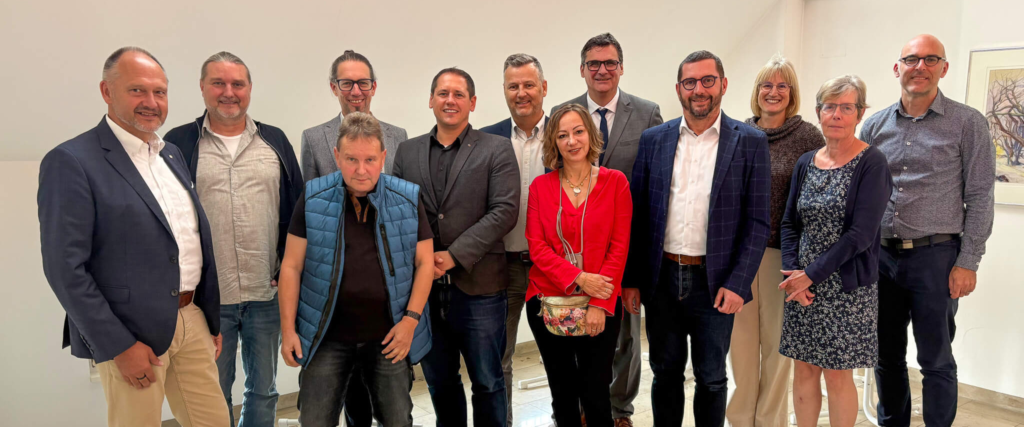Eine Gruppe von Personen posiert in einem hellen Raum für ein Foto.