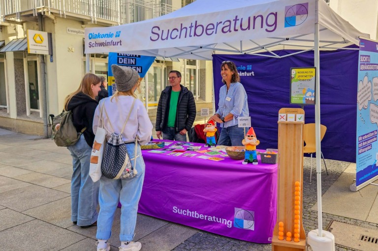 Aktionsstand zur Suchtberatung mit Informierenden und Besuchern in Schweinfurt.