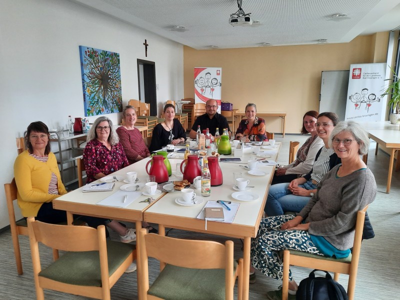 Mitarbeitende sitzen beim Kooperationstreffen gemeinsam an einem Tisch.