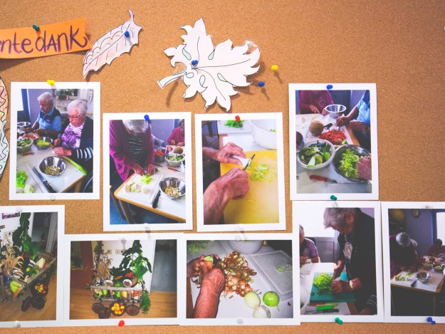 Pinnwand mit Fotos, auf denen Senioren beim Zubereiten von Essen abgebildet sind, dekoriert mit herbstlichen Motiven und dem Schriftzug "Erntedank".