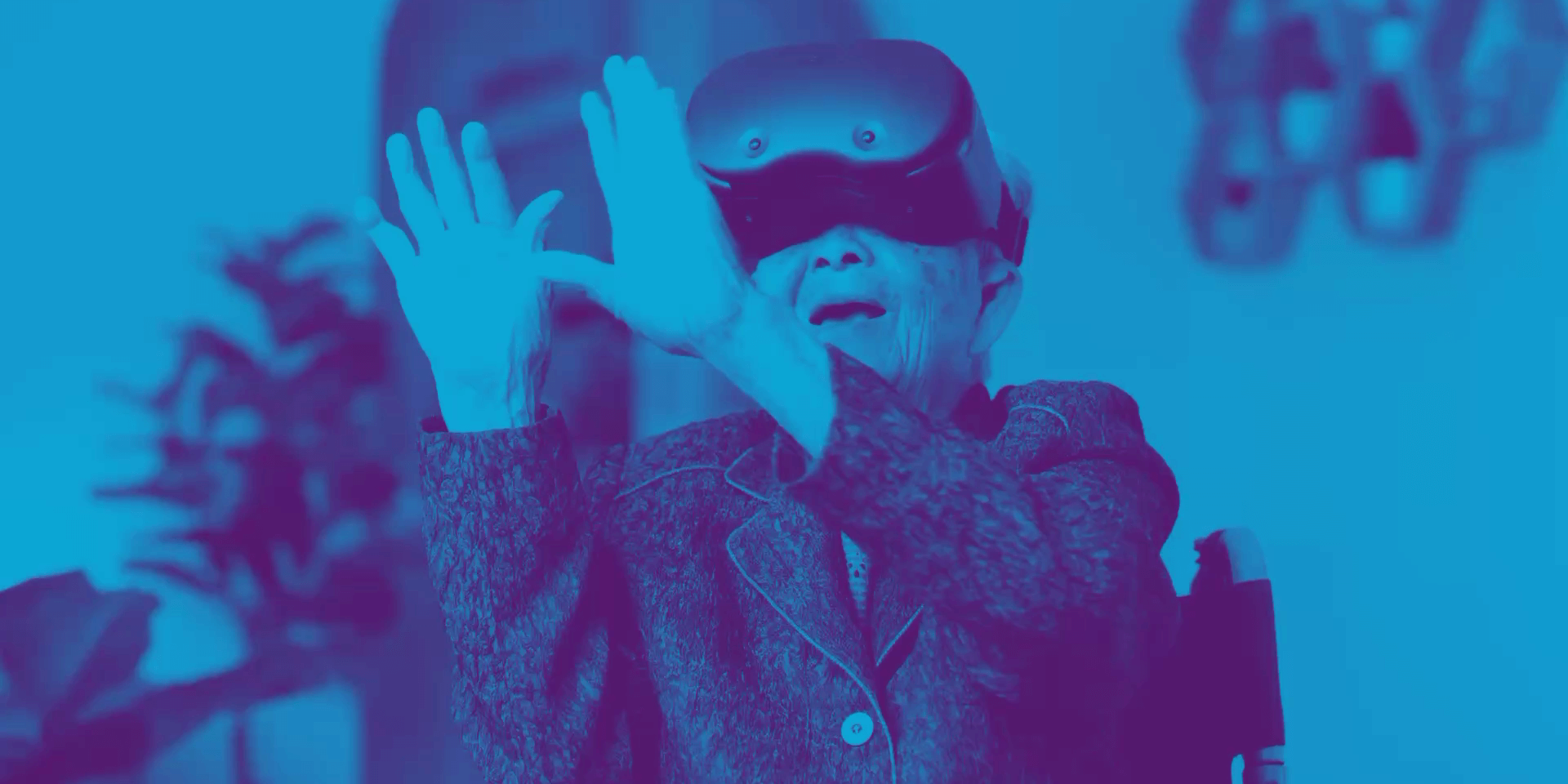 Eine ältere Frau im Rollstuhl nutzt eine VR-Brille.