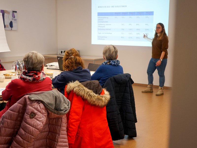 Die Leiterin der Fachstelle für pflegende Angehörige steht vor den Interessierten