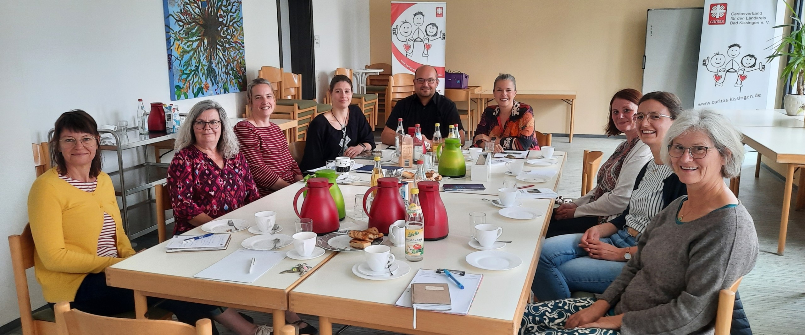 Mitarbeitende sitzen beim Kooperationstreffen gemeinsam an einem Tisch.